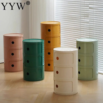 Set of colorful cylindrical storage units on a wooden floor with a window in the background.