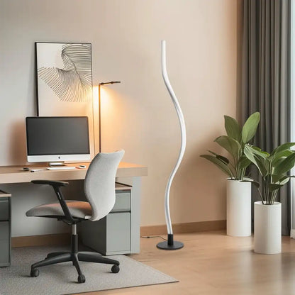 Modern office space with a desk, chair, computer monitor, and decorative elements.