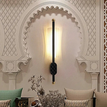 Decorative wall sconce with intricate arch design on a wall.