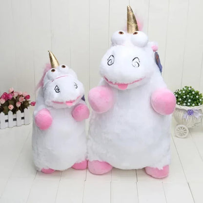 Two plush unicorn toys with pink bodies and gold horns on a white wooden floor.