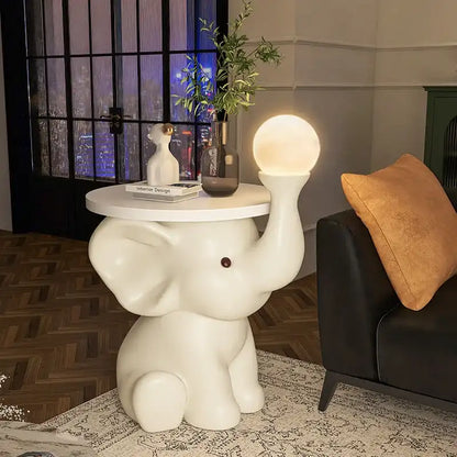 White elephant-shaped side table with a lamp and decor items in a living room setting.