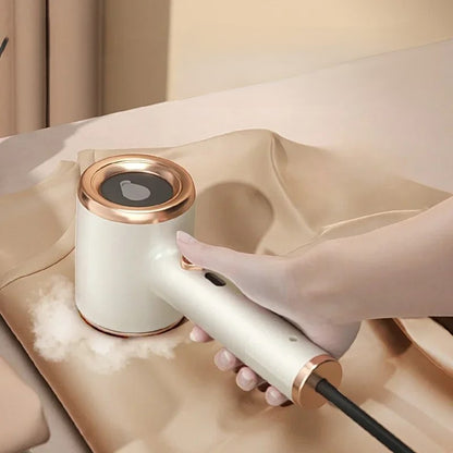 Hand holding a white and rose gold handheld device on a beige surface