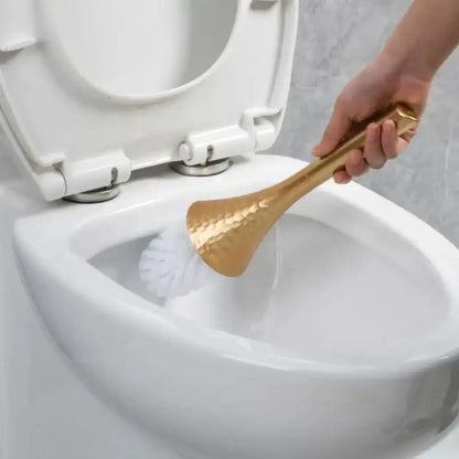 Person cleaning a toilet with a gold-handled brush