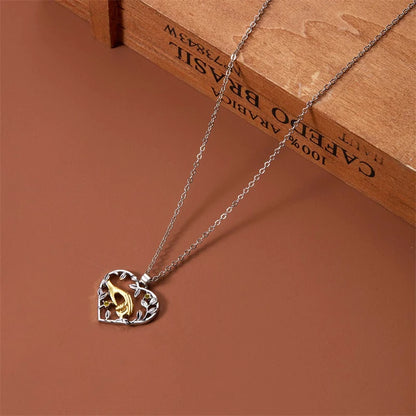 Necklace with a heart-shaped pendant featuring a gold and silver design on a brown surface.