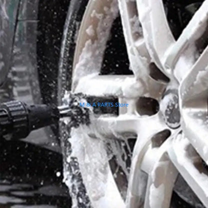 Car wheel being cleaned with a high-pressure washer in snow