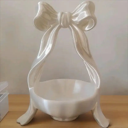 White decorative item with a bow on a wooden surface
