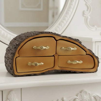 Decorative jewelry box shaped like a tree trunk with drawers on a white surface.