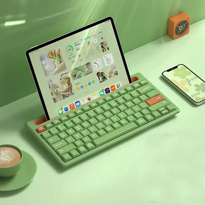 Green keyboard on a desk with a tablet and smartphone in the background
