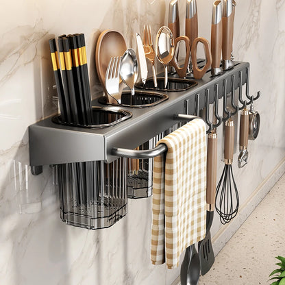 Kitchen utensil holder with various utensils on a marble wall.