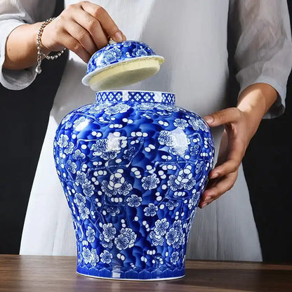 Person holding a large blue and white floral-patterned vase