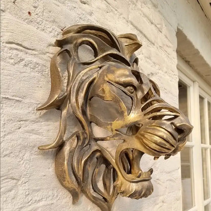 Bronze lion head sculpture on a stone wall
