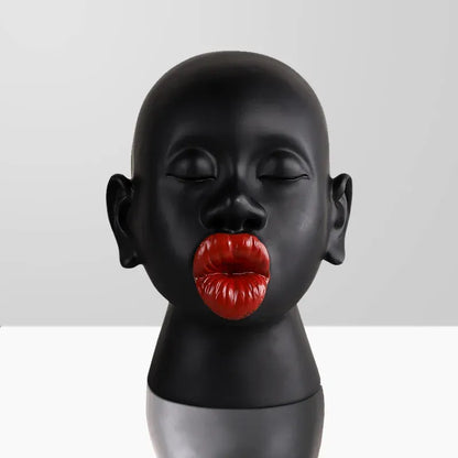 Black mannequin head with red lips on a gray background