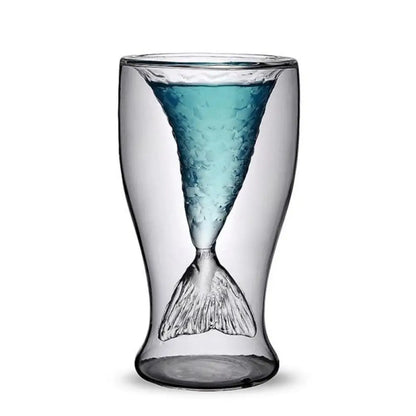 Glass with mermaid tail design and blue interior on a white background