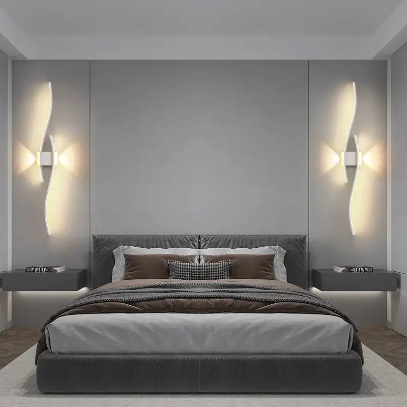 Modern bedroom with a bed, nightstands, and wall lights.