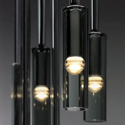 Modern pendant light fixture with glass shades on a dark background