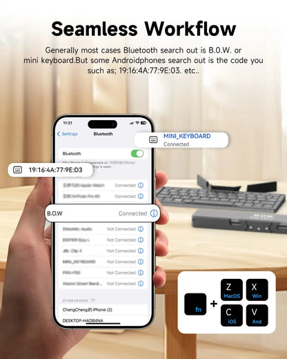 Hand holding a smartphone displaying Bluetooth connectivity with a keyboard in the background.