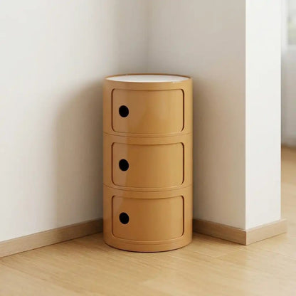 Wooden storage unit with three drawers against a white wall.