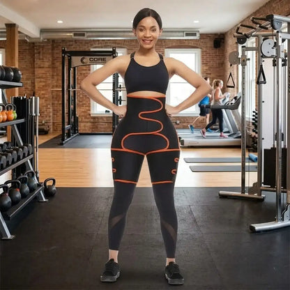 Woman in black athletic wear with orange accents standing in a gym.