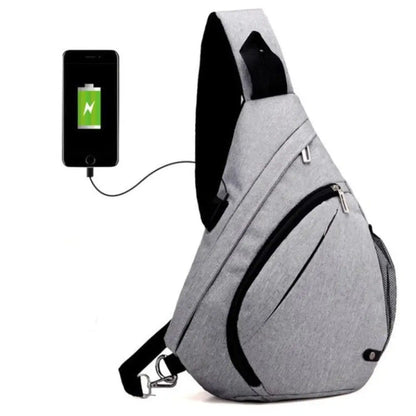 Gray sling bag with USB port charging a smartphone on a white background