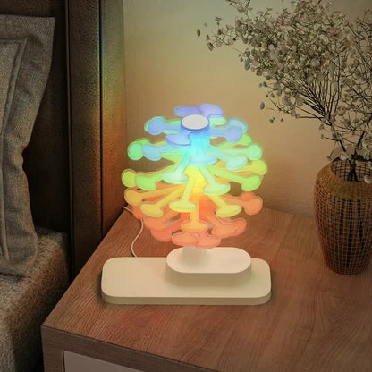 Colorful tree-shaped lamp on a wooden nightstand with a plant in the background
