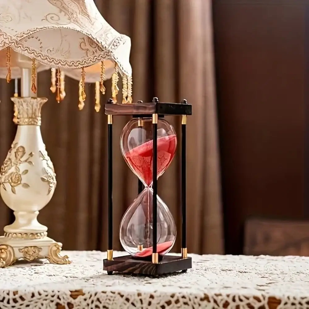 Vintage 60-minute wooden hourglass timer with black sand on an executive desk