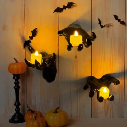 Halloween-themed wall decor with bats, candles, and pumpkins on a wooden background.