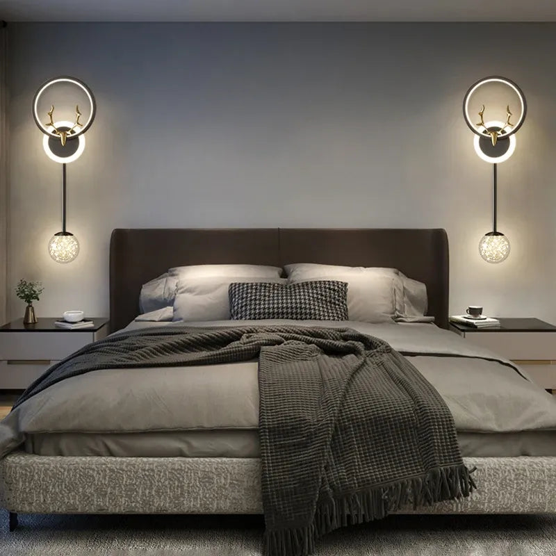 Modern bedroom with a bed, wall lights, and decor.