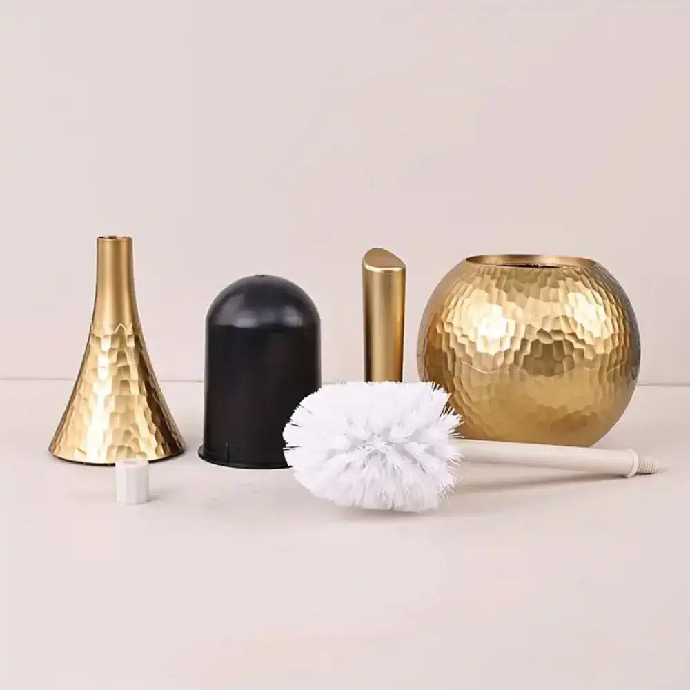 A set of brushes, including gold and black vases and a white brush, on a light background