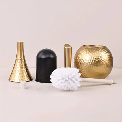 A set of brushes, including gold and black vases and a white brush, on a light background