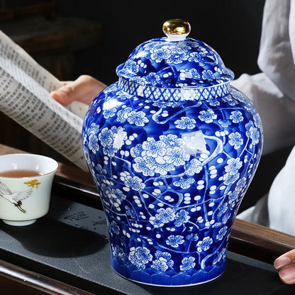Blue and white ceramic jar with floral patterns on a table.