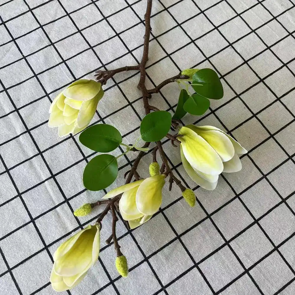 Artificial yellow flowers with green leaves on a grid background