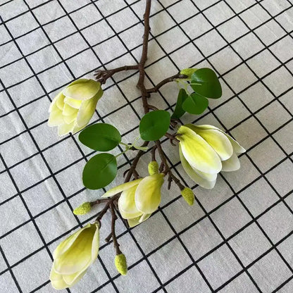Artificial yellow flowers with green leaves on a grid background