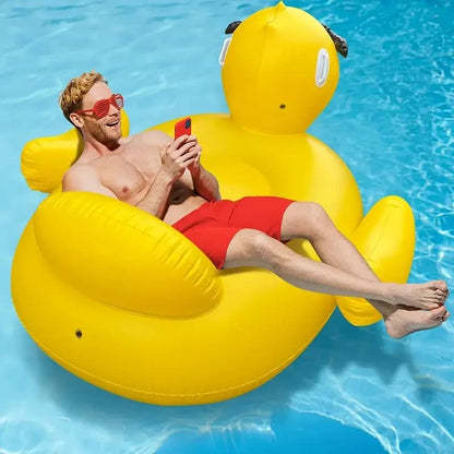 A man is lounging on a yellow inflatable duck float in a pool.
